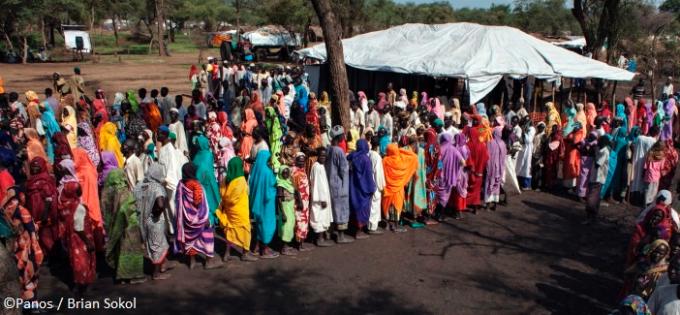 Refugees queue for blankets and mosquito nets at a distribution point in Yusuf Batil Refugee Camp, Upper Nile State, South Sudan. Photo: Brian Sokol / Panos