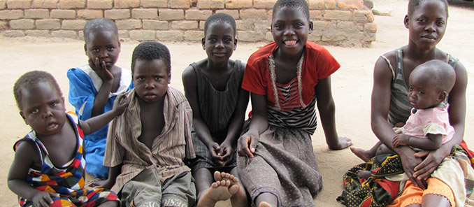 Lise’s seven grandchildren and her great-grandchild pose for photo outside Lise’s home in Malawi.