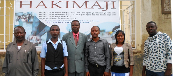 Mr Amosi Kalonge, Ward Executive Officer of Igamba Ward, Mbozi District, Mbeya Region, with Mbeya Highlands FM journalists Samuel Ndoni, Willick Simfukwe, Benny Mbilinyi, Safina Joel, Lusekelo Uswege. Photo: Amandine Oleffe 