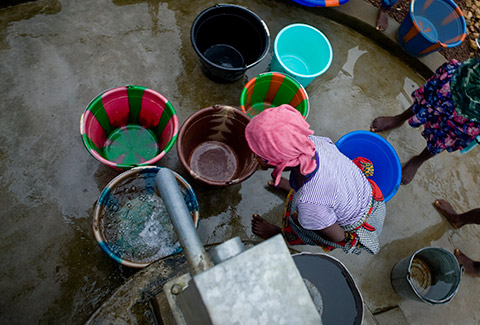 Children gather around a newly installed water pump in Mulbah Town, Liberia. 