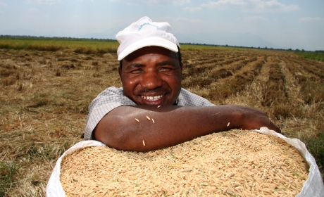 Emanuel Mahendi is photographed in Morogoro, Tanzania, with a sack of rice. Tanzania's ranking in the HDI improved one place in the HDR 2014.