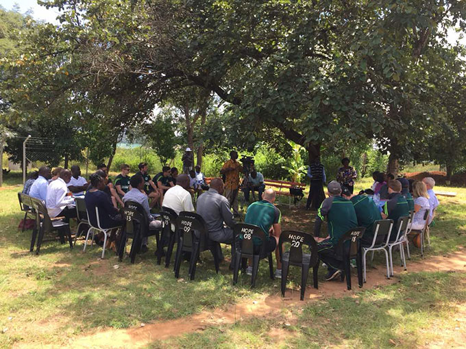 Ireland's Men's Cricket team and Ambassador MacGabhann speak with health workers at Rutope Clinic, Bindura, Zimbabwe